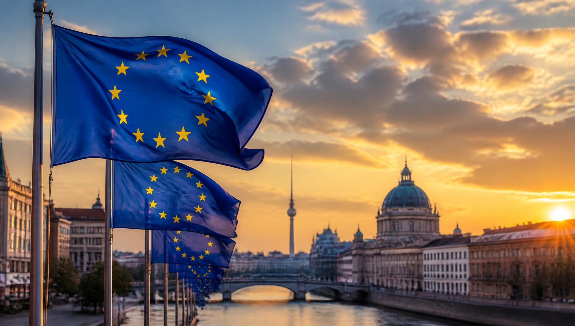 European Union flags waving over a European cityscape at sunset